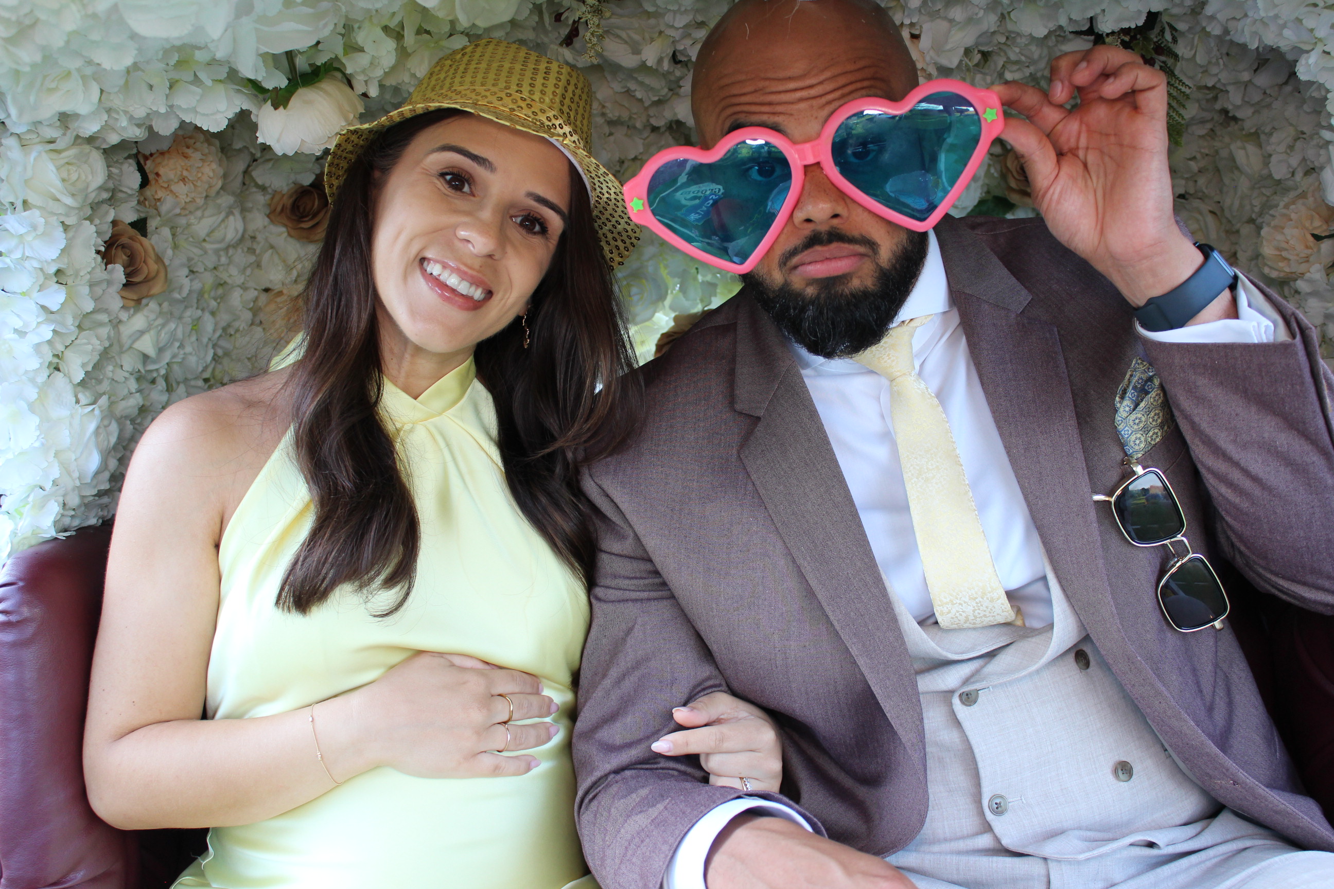 Guest wearing star-shaped sunglasses posing in a bright tuk tuk photobooth